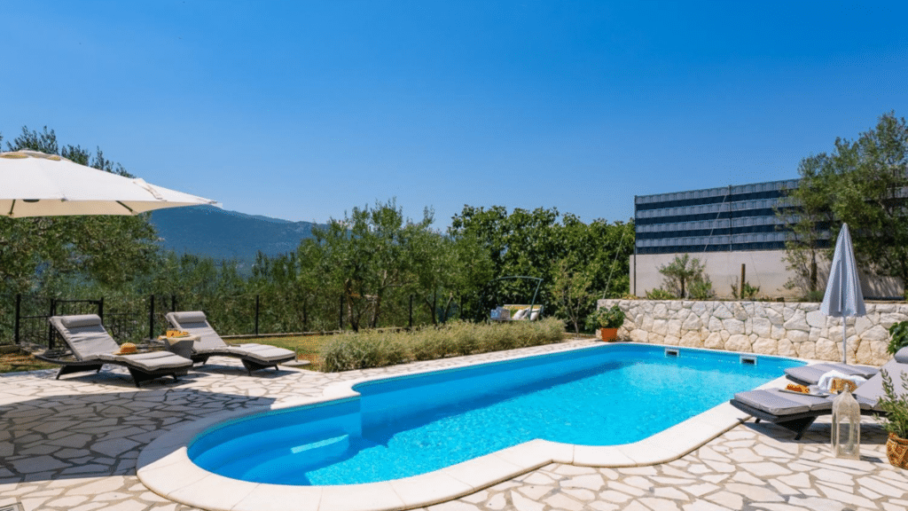 Private swimming pool with sun loungers at a luxury villa in Omis, Croatia