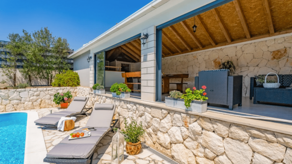 Poolside terrace with sun loungers and covered outdoor seating at the Croatia villa